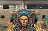 Close-up photo of a dynamic mural painted on a city wall with surreal elements.