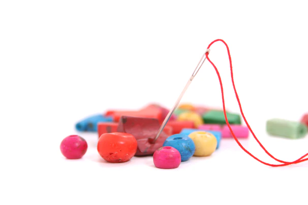 Dazzle art workshop scene with colorful beads and threads scattered around creative hands.