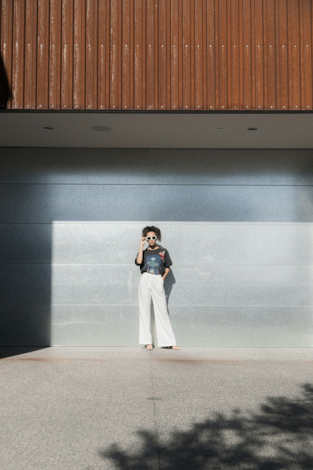 woman standing on gray concrete flooring during daytime