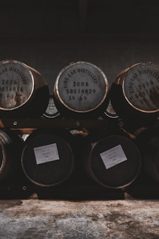 A distillery with copper stills and barrels bathed in warm light.
