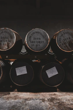 A rustic distillery setting with wooden barrels and warm lighting.