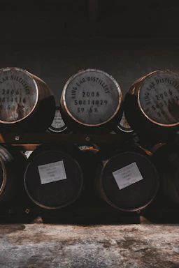 A cozy rustic office space with whiskey barrels and warm lighting.