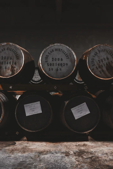 A rustic distillery setting with wooden barrels and warm lighting.