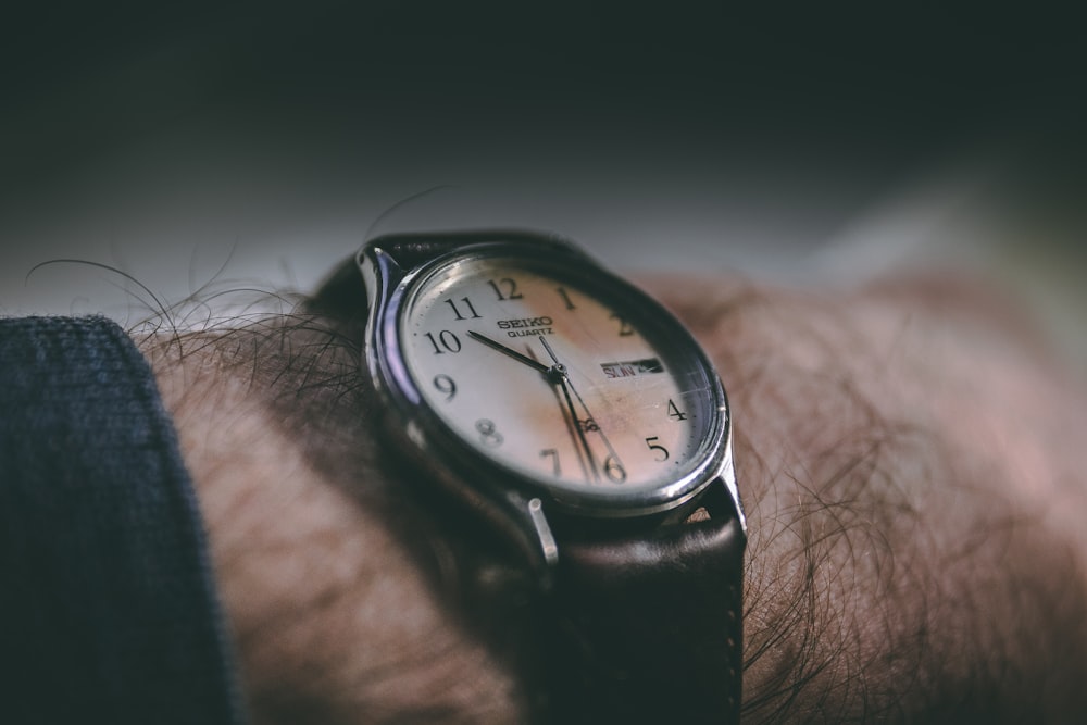 photo of round black analog watch