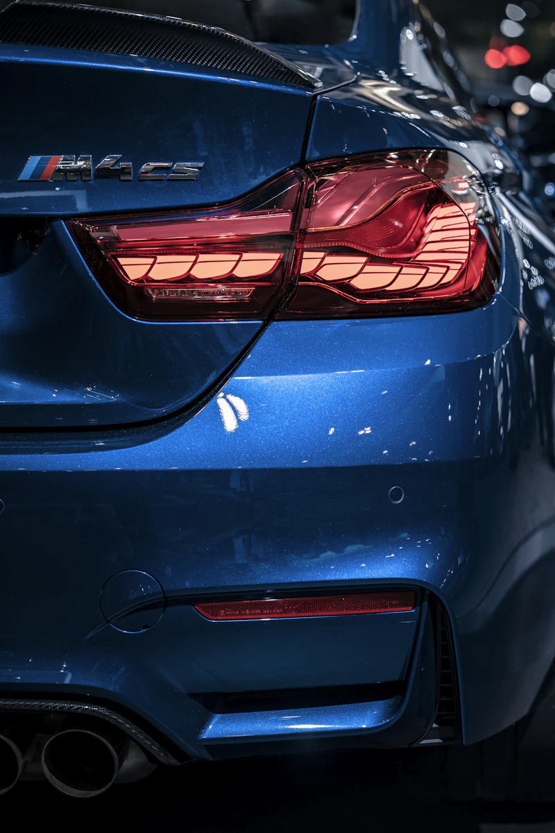 Macro shot of a glossy ceramic-coated taillight and rear panel reflecting city lights