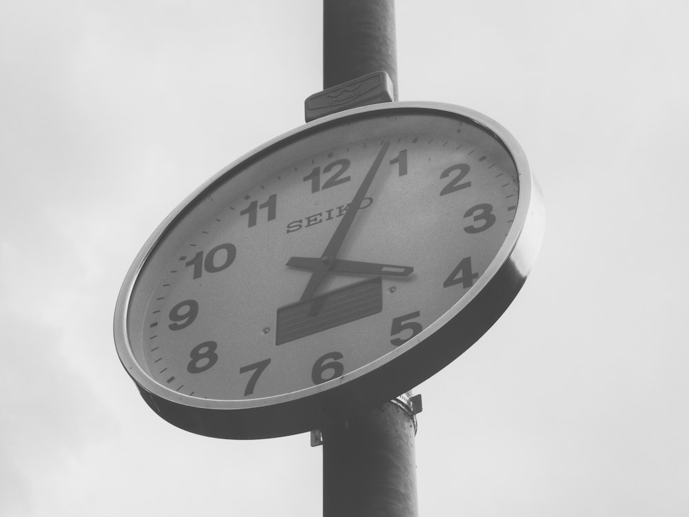 4:04を表示する壁掛け時計のグレースケール写真