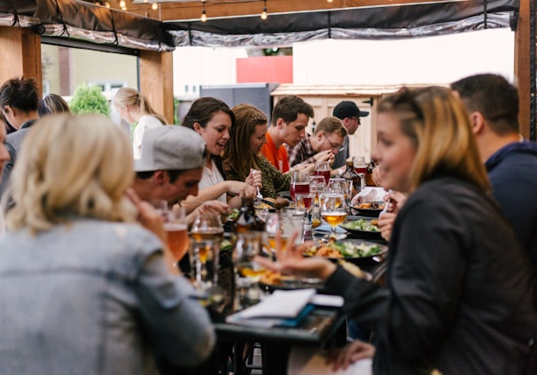 people sitting in front of table talking and eating