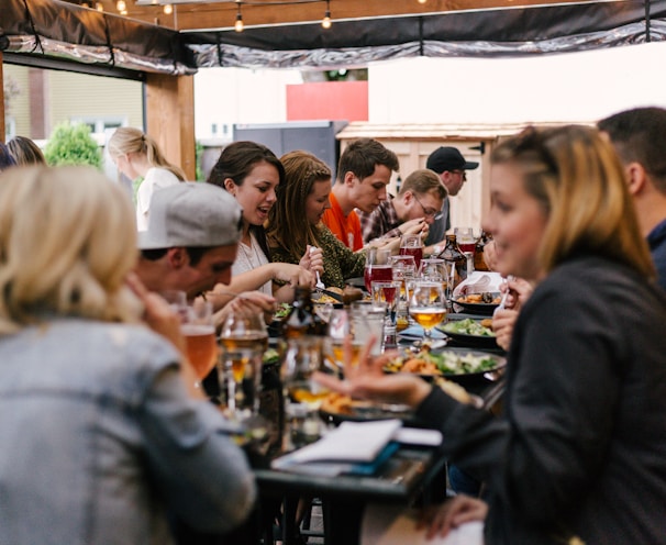 people sitting in front of table talking and eating