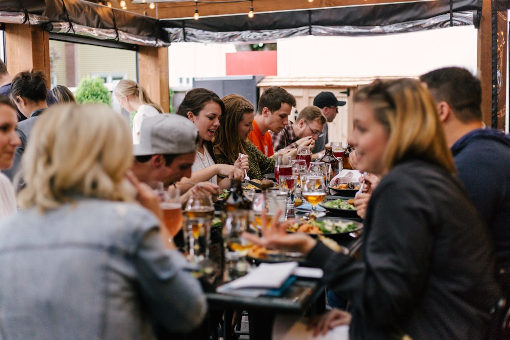 people sitting in front of table talking and eating