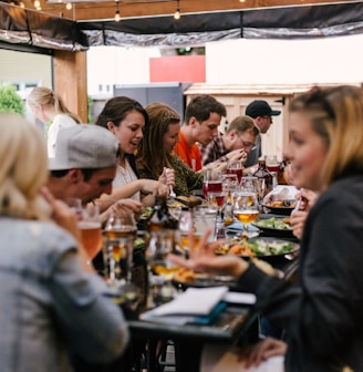 people sitting in front of table talking and eating