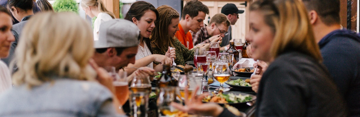 people sitting in front of table talking and eating