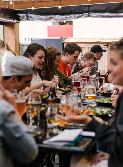 people sitting in front of table talking and eating