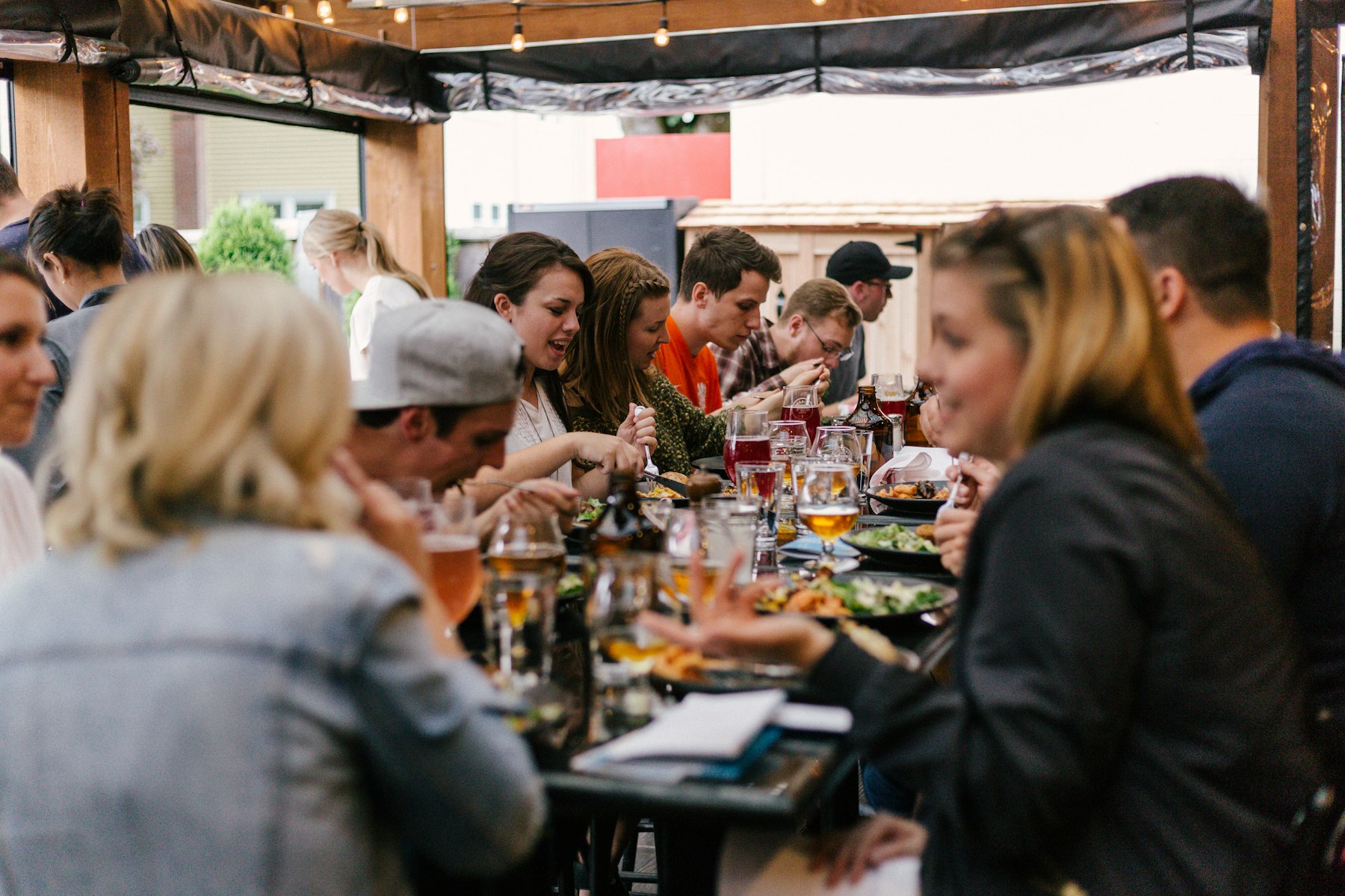 Friends at a packed restaurant table with drinks