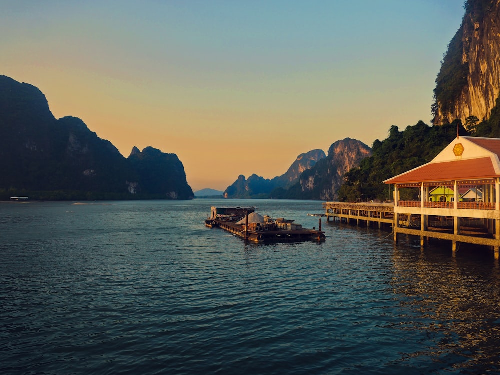 floating restaurant on body of water near mountains