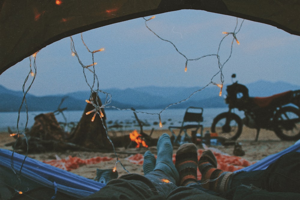 a person laying in a tent with their feet up