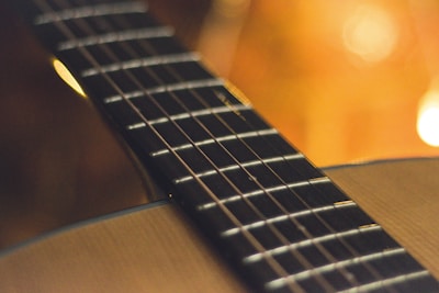 Close-up of guitar strings being strummed with warm lighting.