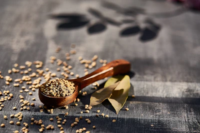 Golden fenugreek seeds spilling gently from a rustic wooden spoon.