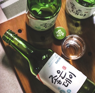 three Kanji script text bottles on wooden panel