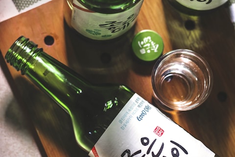 three Kanji script text bottles on wooden panel