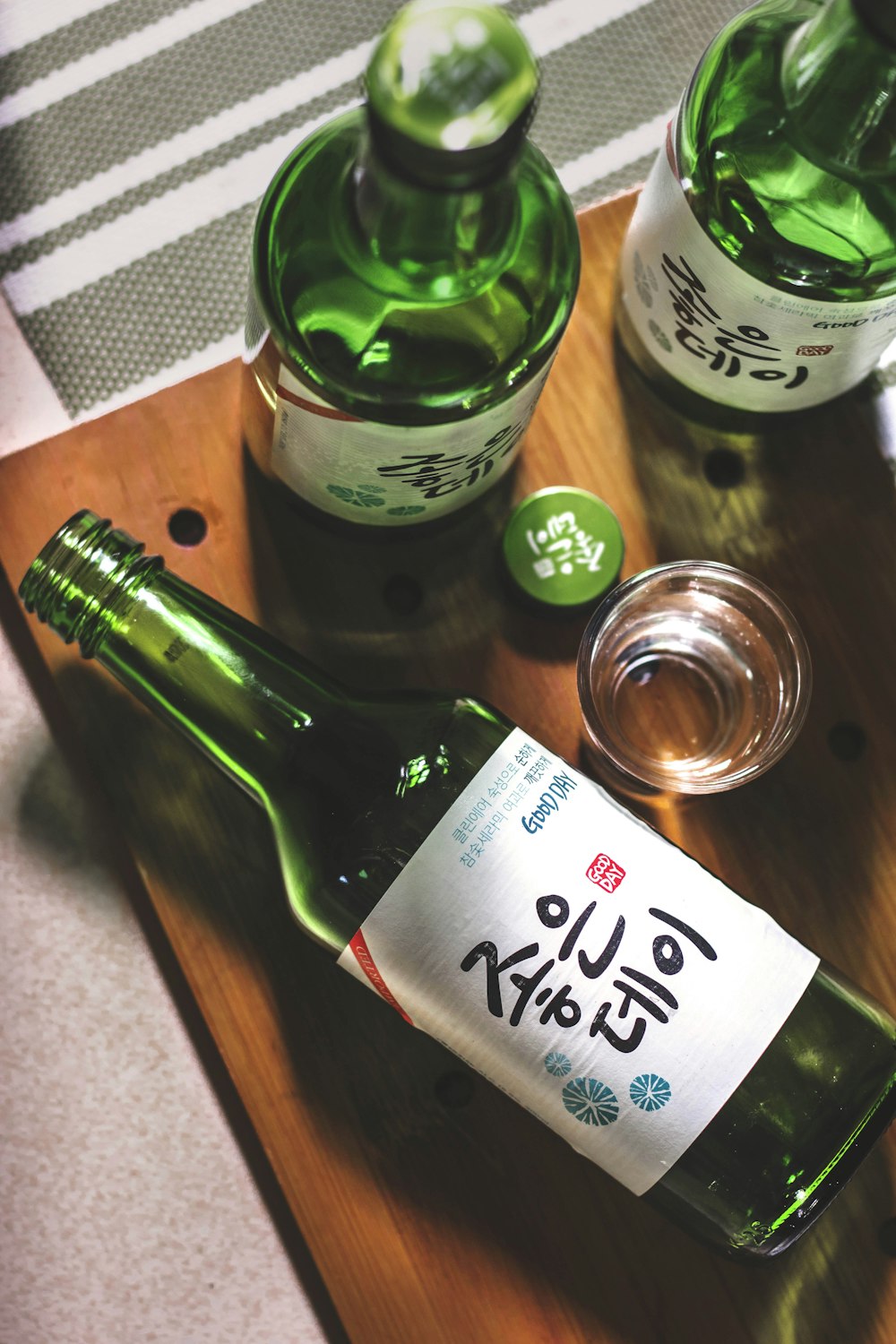 three Kanji script text bottles on wooden panel