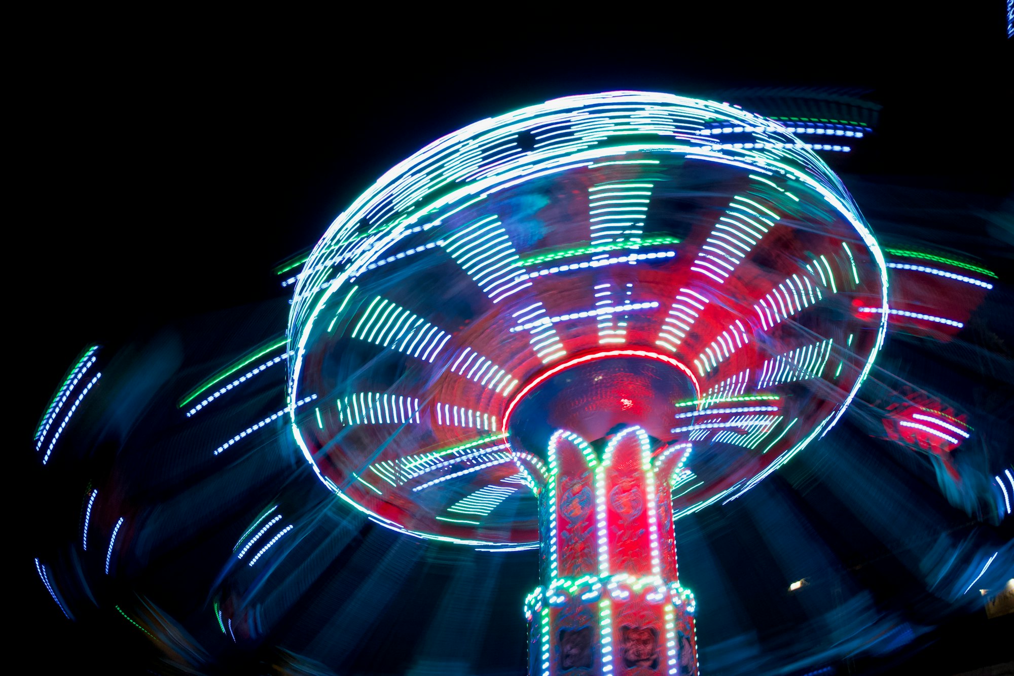 a time-lapsed spinning amusement park ride at night