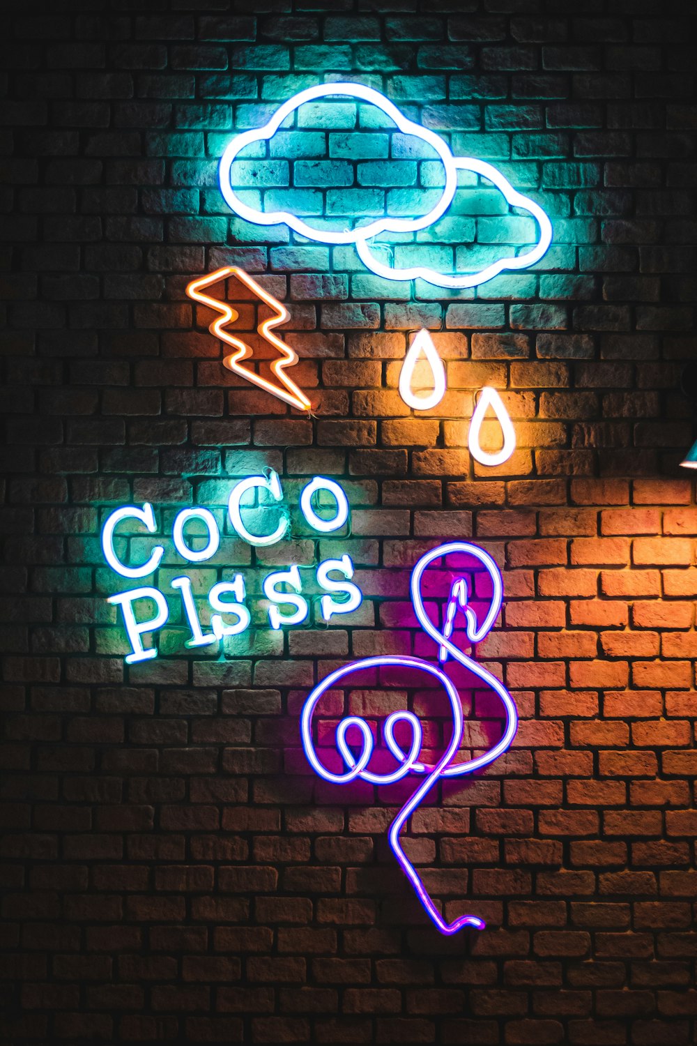 Coco Plsss neon signage hanging on brick wall