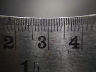 Close-up of a chain being measured against a ruler to determine the exact length.
