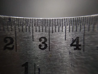 Close-up of a chain being measured against a ruler to determine the exact length.