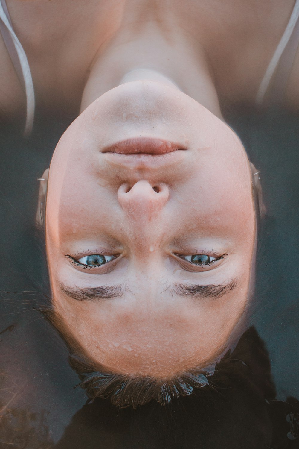 Mulher deitada no corpo da água na fotografia do closeup