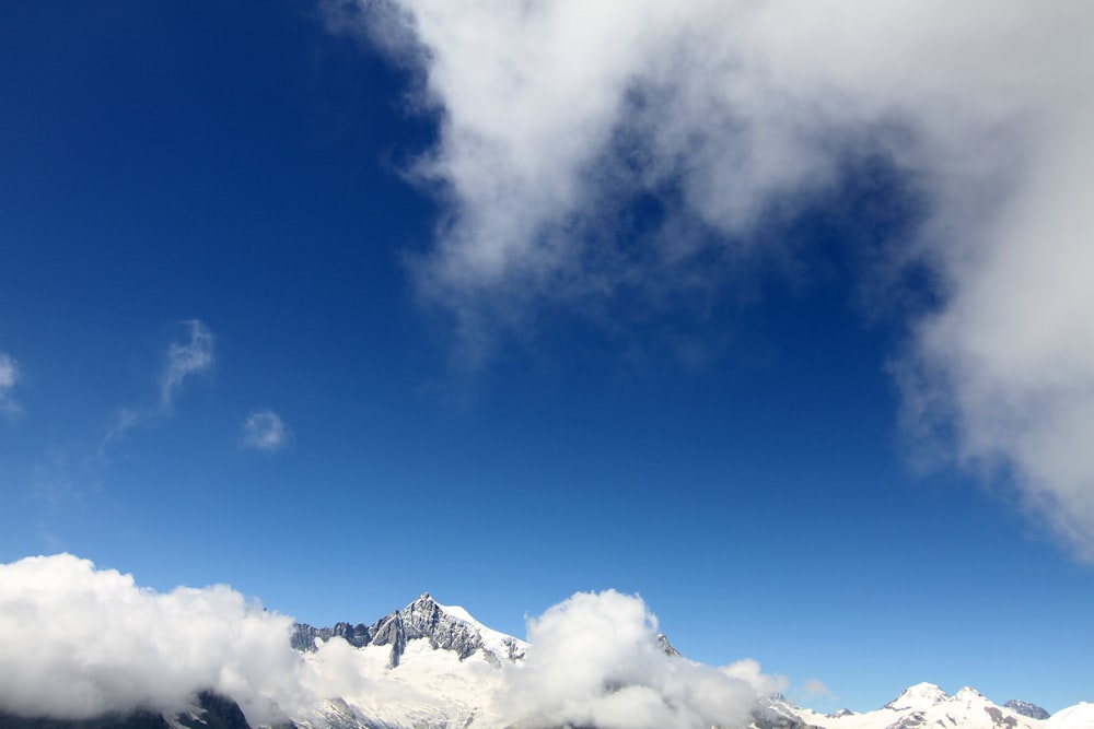 snow covering mountain under blue sky