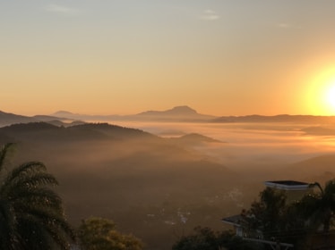 A serene view of the misty mountains and winding rivers in Yunnan at sunrise.