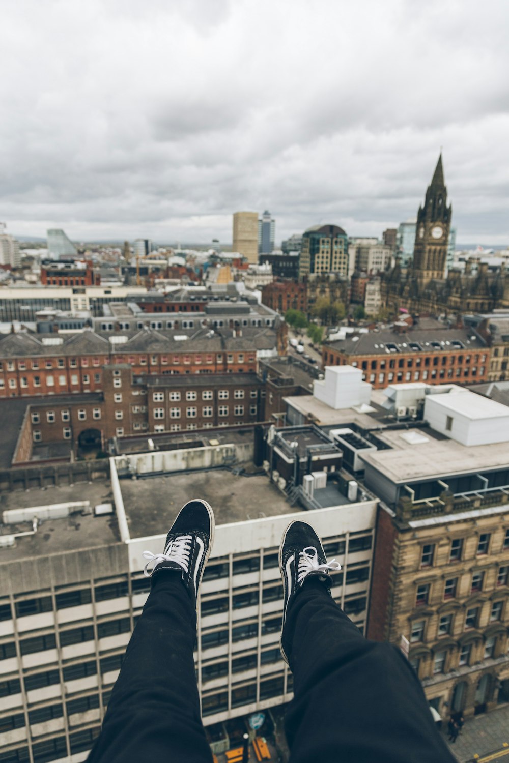 person sitting on edge of building rooftop