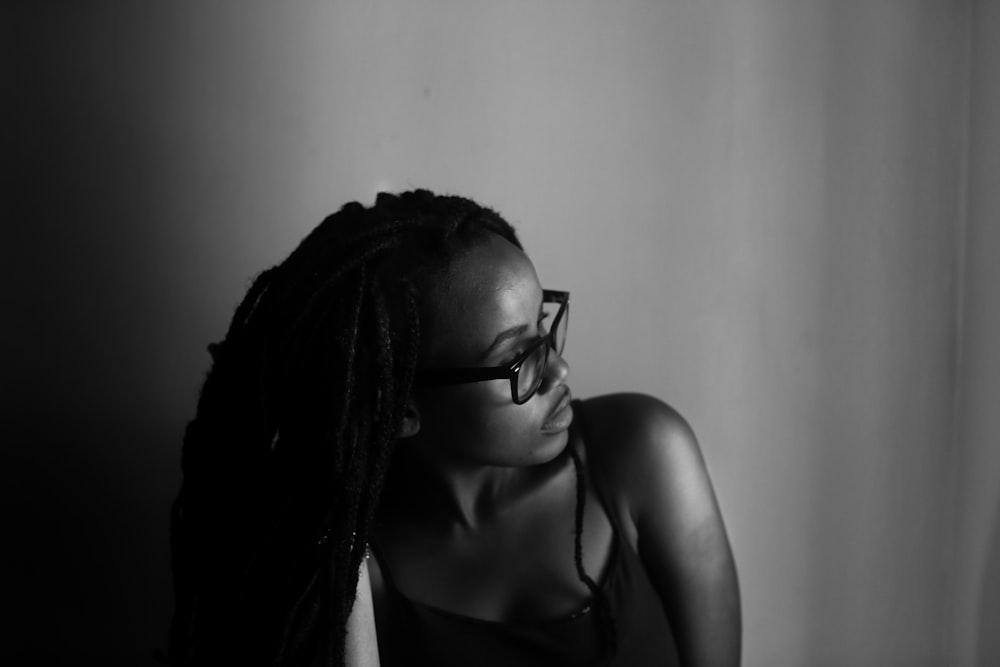 grayscale photo of woman staring at window