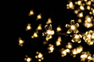 Delicate silicone charms hanging from a light lavender backdrop, glowing softly.