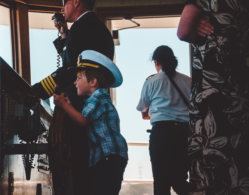 Menino em top xadrez usando chapéu de capitão de navio