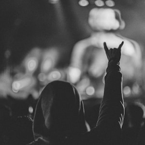 grayscale photo of person in hoodie top watching a concert