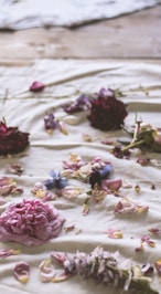 pink petaled flower on white fabric