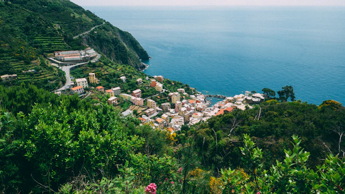 A serene coastal village in a blue zone with vibrant local art and lush greenery.