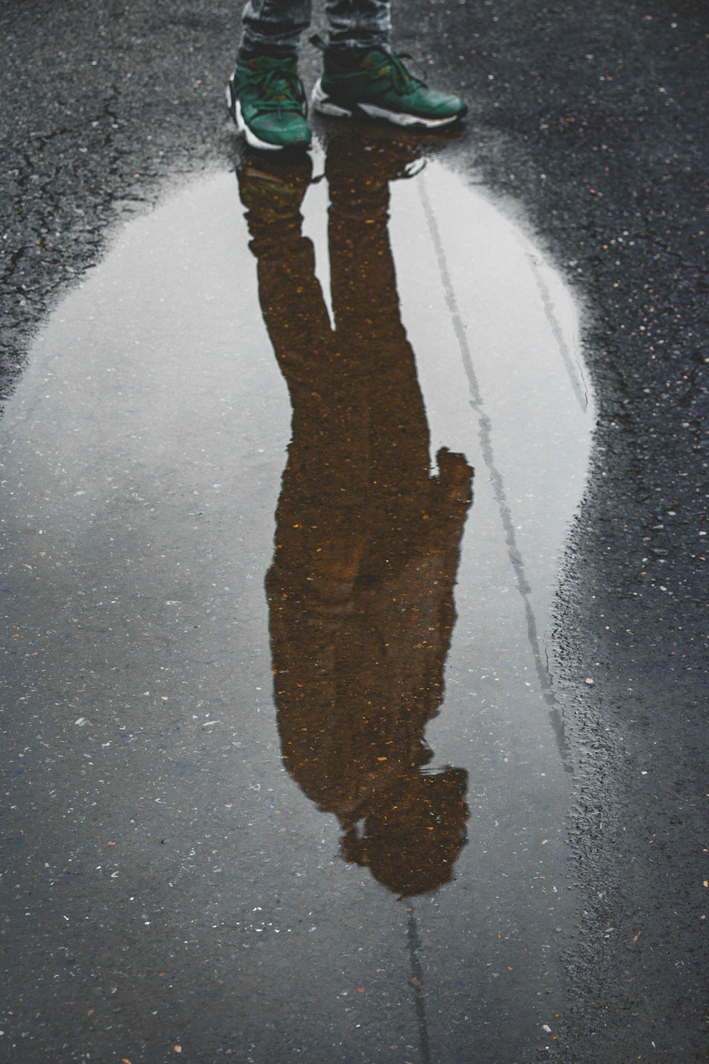 Fotografía de reflexión de la persona parada sobre el agua