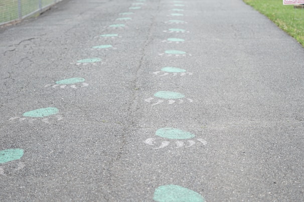 The paw print logo displayed on a wooden signpost outside a pet-friendly community center.