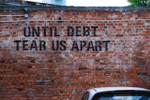 until debt tear us apart brick wall vandal