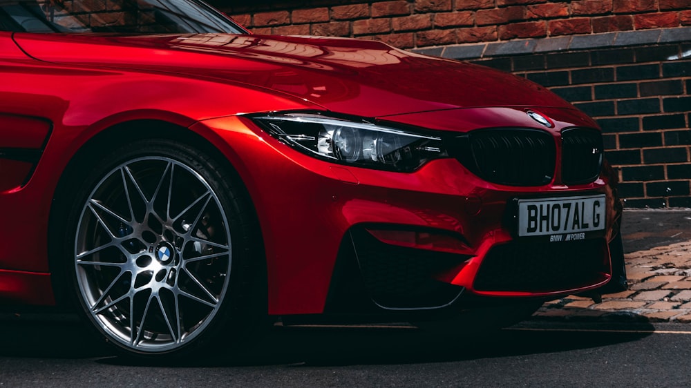 red BMW vehicle park on road