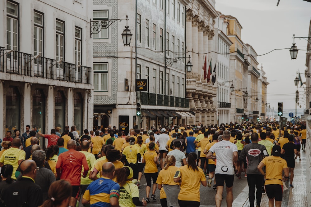 Multitud de personas corriendo en la calle cerca de los edificios durante el día