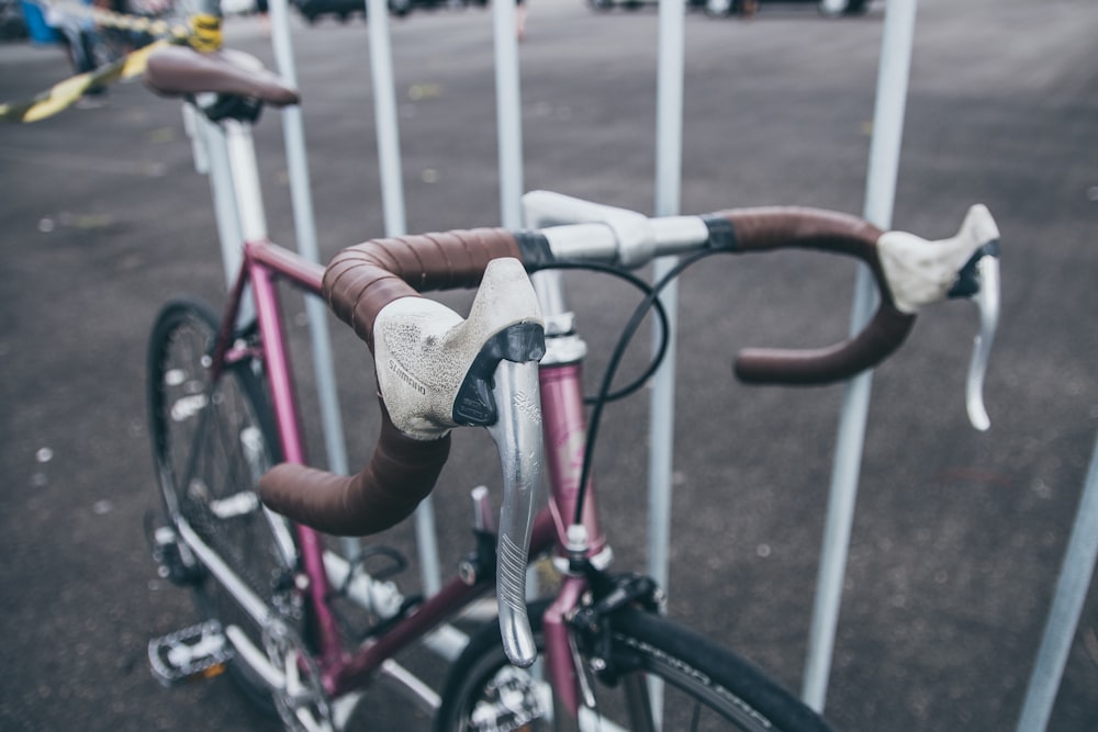 brown and pink road bike parked at the road