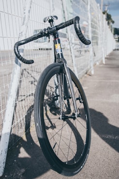 A close-up of a bicycle being tuned up with tools on a sunny day.
