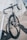 black and white road bike parked beside metal fence