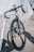 black and white road bike parked beside metal fence