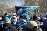 Fans cheering wildly at a packed Philadelphia Eagles game in the stadium.