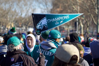 man holding philadelphia eagle pennant super bowl teams background