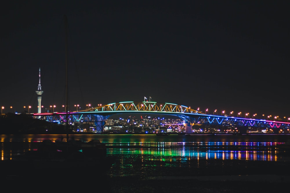 bridge with lights over body of water at nighttime